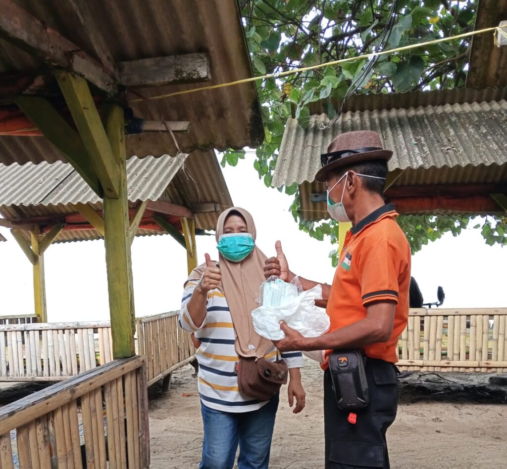 Personil BPBD Kabupaten Serang membagikan masker kepada masyarakat sebagai upaya perlindungan dari paparan abu vulkanik Gunung Anak Krakatau, Minggu (6/9)