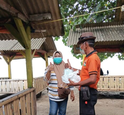 Personil BPBD Kabupaten Serang membagikan masker kepada masyarakat sebagai upaya perlindungan dari paparan abu vulkanik Gunung Anak Krakatau, Minggu (6/9)