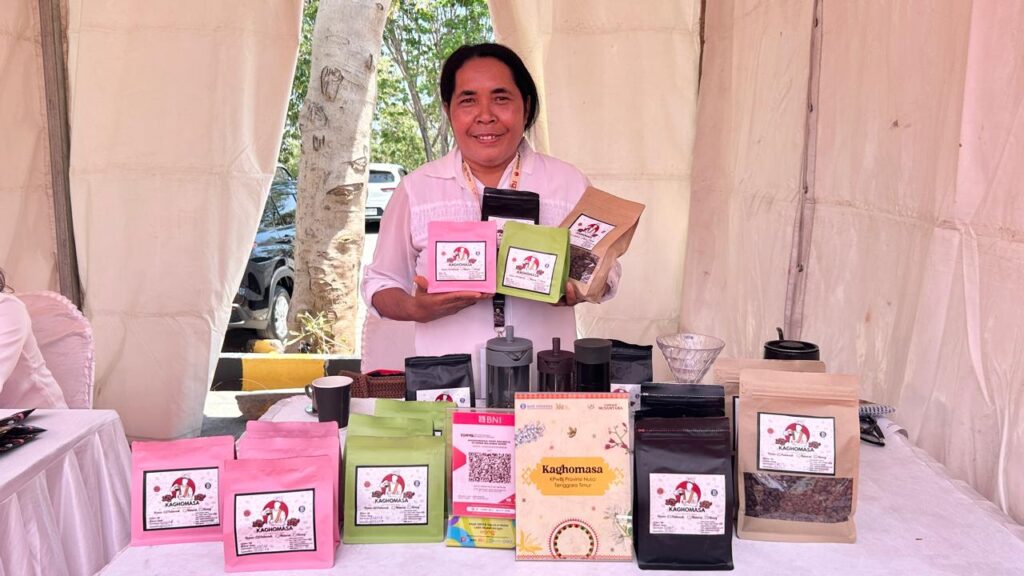 Petani Kopi Arabika Bajawa, Mama Marselina Walu foto bersama produk - produk kopi dalam kemasan saat Flobamorata Creative Expo (FCE) 2026 di Kupang