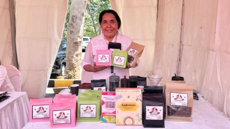 Petani Kopi Arabika Bajawa, Mama Marselina Walu foto bersama produk - produk kopi dalam kemasan saat Flobamorata Creative Expo (FCE) 2026 di Kupang